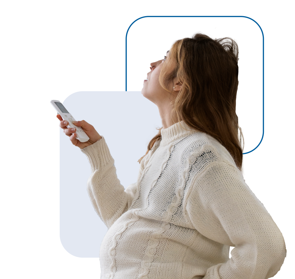 mujer embarazada usando un mando a distancia para controlar las funciones del sistema de climatización instalado en su hogar